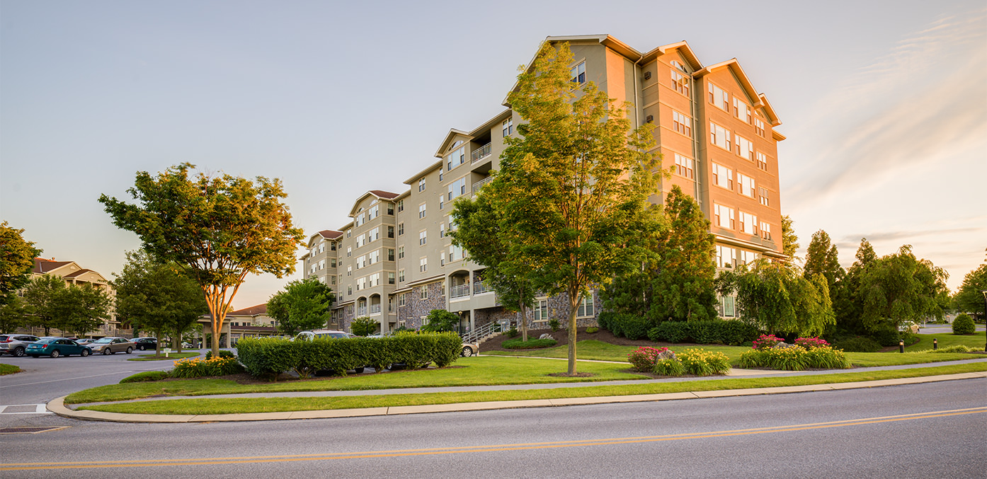 Residential apartment building with well manicured yard and flowerbeds surrounding the building